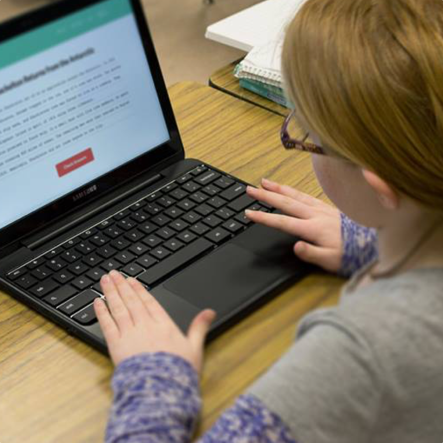 A photograph taken over a student's shoulder of a laptop being used to complete a Quill activity