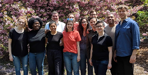 A group photo of Quill employees posing in front of a blossoming cherry tree
