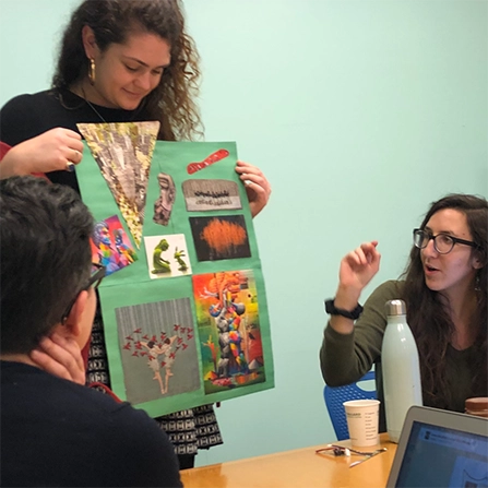 A photograph of a Quill employee presenting a collage to fellow employees